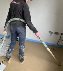 ADM Floor Screed Worker Pouring Liquid Screed Over Pipes