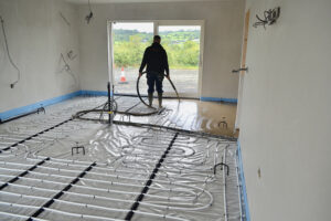 ADM Floor Screed Worker Pouring Liquid Screed Over Pipes